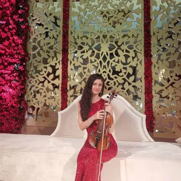 Anna Petrasian performing at luxury venue in red dress